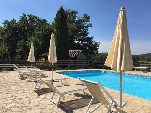 a group of chairs and umbrellas next to a pool at Fattoria Agriturismo Nerbona in Casole dʼElsa
