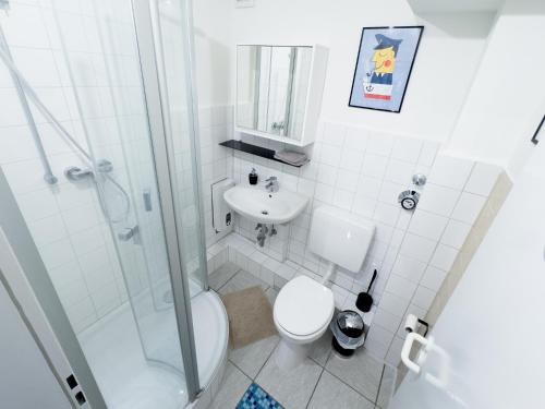 biała łazienka z toaletą i umywalką w obiekcie Basement Küchgarten w mieście Hamburg