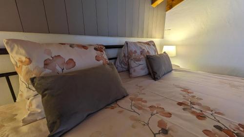 uma cama com almofadas num quarto em Hotel Beau-Séjour em Leukerbad