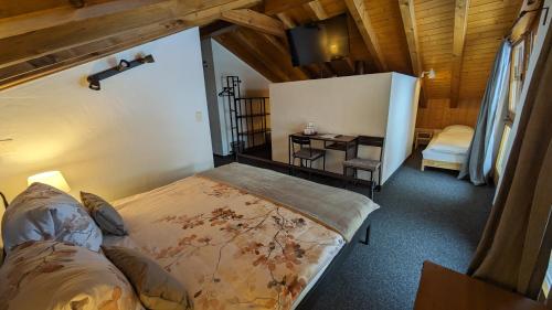 a bedroom with a bed and a desk in a room at Hotel Beau-Séjour in Leukerbad