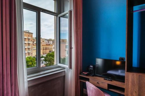 a room with a tv and a window with a view at Momento Soggiorno di Charme in Foggia