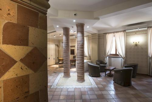 a lobby with two columns and chairs and a table at Hotel Sesmones in Lodi