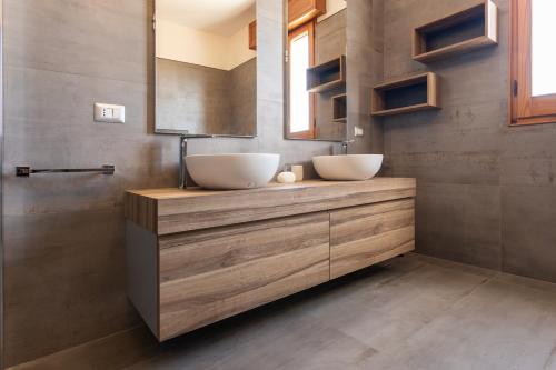 een badkamer met twee witte kommen op een houten wastafel bij Trilocale Concita a Ugento - Apulia Home in Ugento