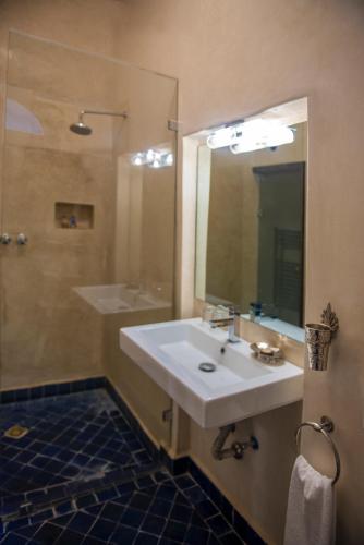 a bathroom with a sink and a mirror and a shower at Riad Palais Bahia Fes in Fès