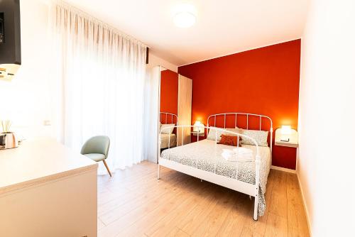 1 dormitorio con paredes de color naranja y 1 cama en una habitación en b&b All'Angelo, en Negrar
