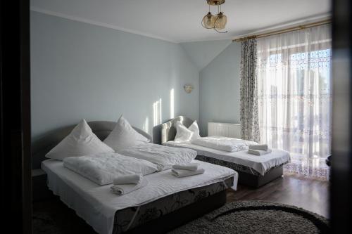 1 dormitorio con 2 camas y ventana en Pensiunea Marinela, en Sighetu Marmaţiei