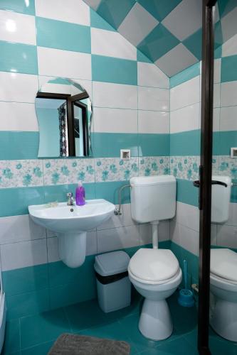 a blue and white bathroom with a toilet and a sink at Pensiunea Marinela in Sighetu Marmaţiei