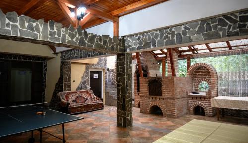 a living room with a brick fireplace and a table at Pensiunea Marinela in Sighetu Marmaţiei