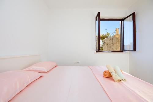 a white bedroom with a bed and a mirror at Apartment Mare in Dubrovnik