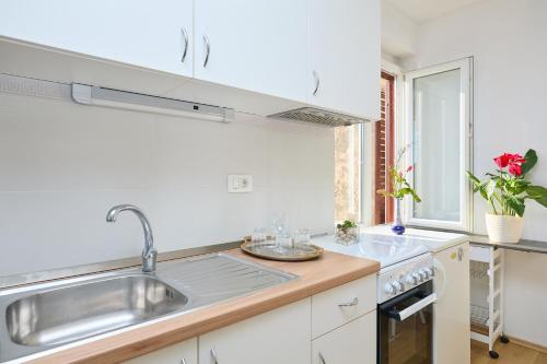 a kitchen with white cabinets and a sink at Apartment Mare in Dubrovnik