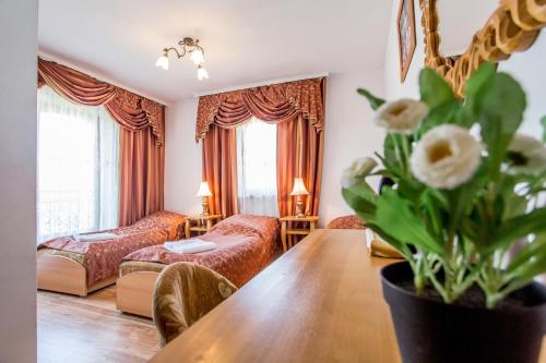 a living room with a large wooden table in a room at Pod Modrzewiami in Zakopane