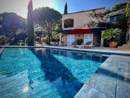 a swimming pool in front of a house at Villa Thalassa Art' B&B in Le Lavandou