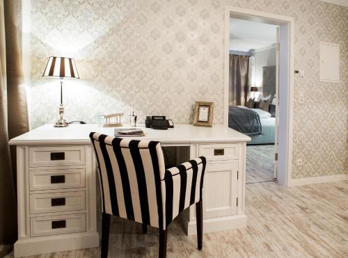 a bedroom with a desk with a lamp and two chairs at Klosterhotel Neuzelle in Neuzelle