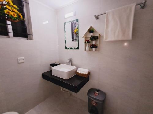a bathroom with a white sink and a toilet at GR MEET & GREET in Dhaka