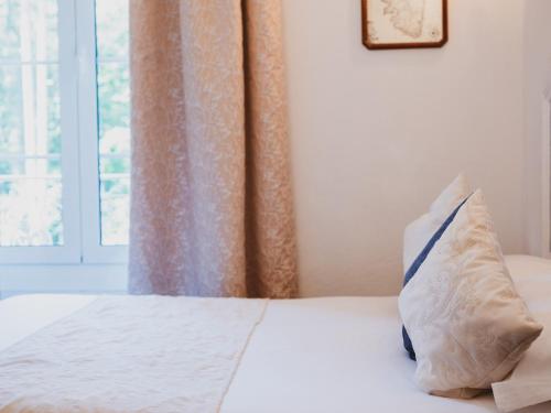 a bed with a pillow on it with a window at Hôtel Restaurant U Castellu Vizzavona in Vizzavona