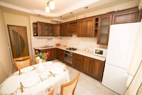 利維夫的住宿－новобуд 2 кімнати Вернадського 8，厨房配有桌子和白色冰箱。