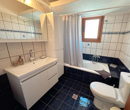 a bathroom with a sink and a toilet and a tub at Living Home Trikala in Tríkala