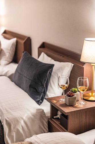 two glasses of wine on a night stand next to a bed at PEACE OF REST TAKASHIMA in Takashima