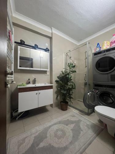 een badkamer met een wastafel en een wasmachine bij BABİLON REZİDANS APARTMANI in Rize
