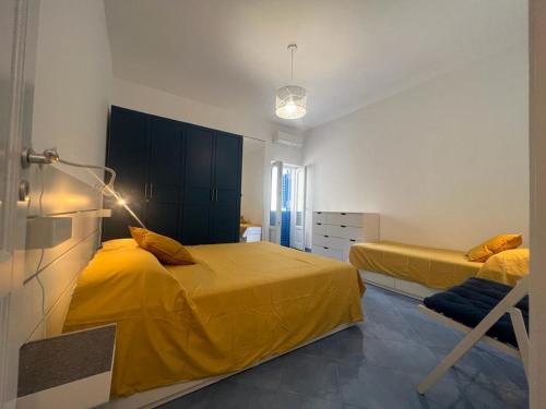 una camera con due letti con lenzuola gialle di Luxury apartments Caucich a Città di Lipari