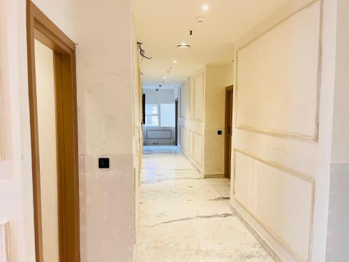 a hallway with white walls and marble floors at Hotel IP Swarn near Anand Vihar Vaishali Ghaziabad in Ghaziabad