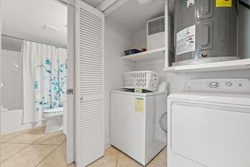 uma lavandaria branca com máquina de lavar e secar roupa em Perdido Towers East 801 em Perdido Key
