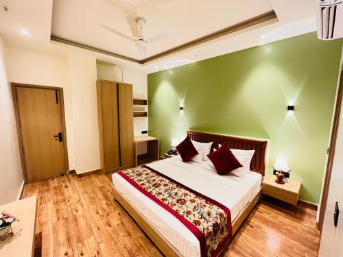 a bedroom with a bed and a green wall at Hotel IP Swarn near Anand Vihar Vaishali Ghaziabad in Ghaziabad