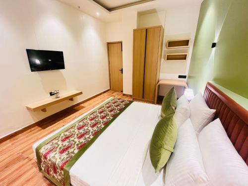a large bed in a room with a television at Hotel IP Swarn near Anand Vihar Vaishali Ghaziabad in Ghaziabad
