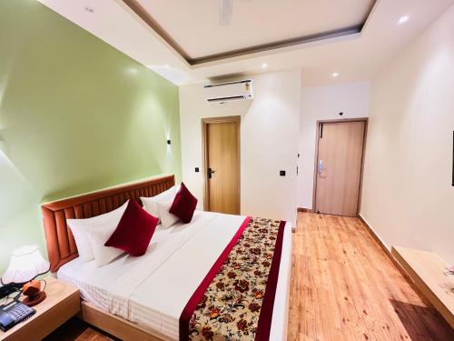a bedroom with a large bed with red pillows at Hotel IP Swarn near Anand Vihar Vaishali Ghaziabad in Ghaziabad