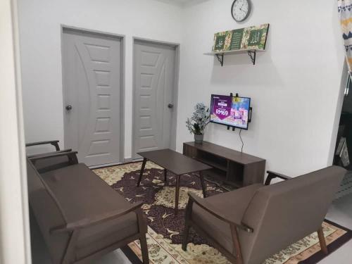 萬津的住宿－D'Parking Homestay Klia Sepang Budget Murah，客厅配有两把椅子、一张桌子和闹钟