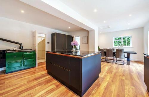 an open kitchen with a green island in a house at Luxury Hot Tub Home Torquay in Torquay
