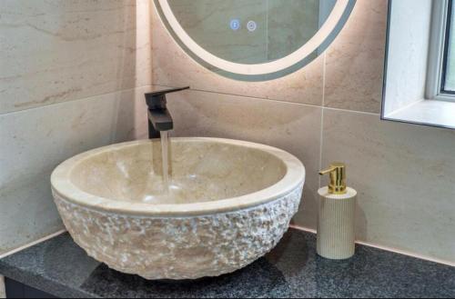 een stenen wastafel in een badkamer met een spiegel bij Luxury Hot Tub Home Torquay in Torquay