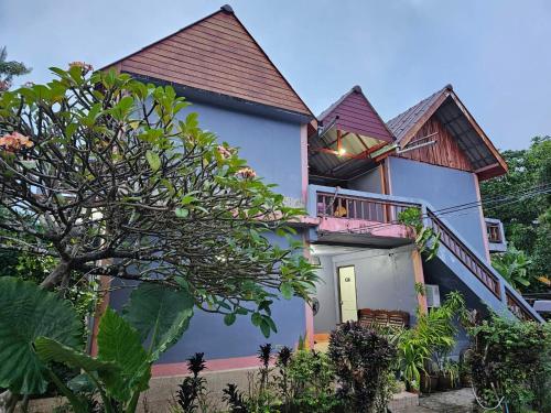 een huis met een veranda en een balkon bij hello meme house in Koh Lanta