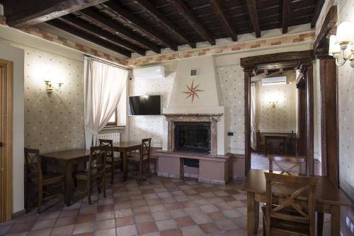 a living room with a table and chairs and a fireplace at Hotel Sesmones in Lodi