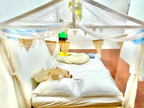 two teddy bears laying on a bed with a canopy at Getaway Villa Bangkok - 4 Bedroom,6 Beds and 5 Bathroom in Bangkok