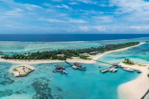 an island in the ocean with boats in the water at Le Méridien Maldives Resort & Spa in Lhaviyani Atoll
