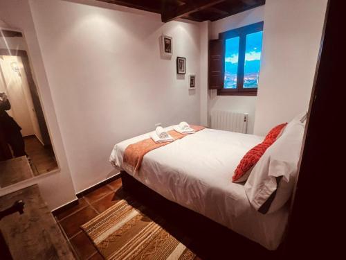Un dormitorio pequeño con una cama y una ventana. en Rascacielos San Martín, en Cuenca