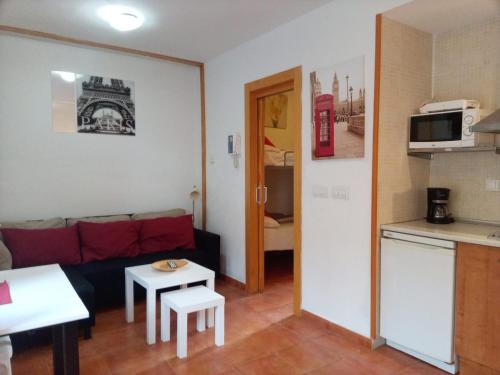 een kleine woonkamer met een bank en een keuken bij ZONA BAJA, Estudio y Garaje opcional in Sierra Nevada