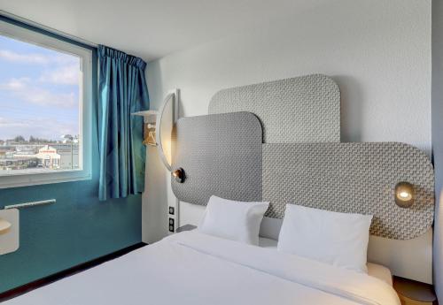 サン・ヴィクトルにあるB&B HOTEL Montluçon Saint-Victorのベッドと窓が備わるホテルルーム