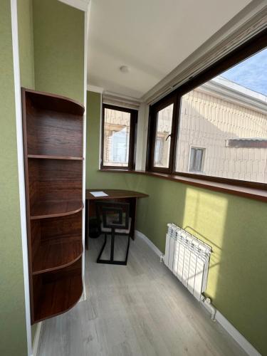 an empty room with a desk and a window at The nest above the clouds in Yakkasaray