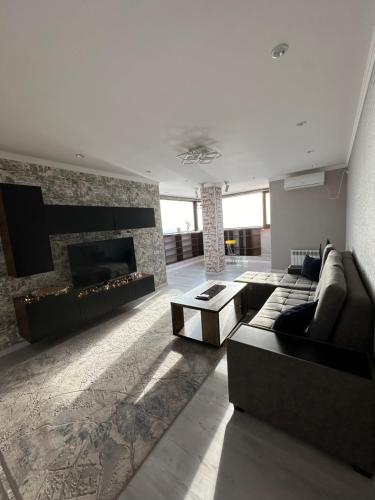 a living room with a couch and a fireplace at The nest above the clouds in Yakkasaray