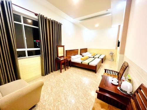 a hotel room with a bed and a couch and a table at Khách Sạn Xuân Huỳnh 3 Sóc Trăng in Soc Trang