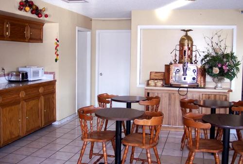 a kitchen with two tables and chairs in a room at Value Inn & Suites - Harlingen in Harlingen