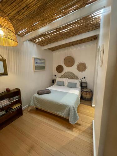 a bedroom with a bed and a wooden floor at Dreamtime Studio in Kommetjie