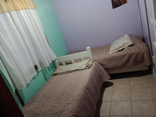 two twin beds in a room with a window at Cabaña hospedaje mis nietas AJB in Las Compuertas