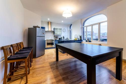 Il dispose d'une grande cuisine avec une table et un réfrigérateur. dans l'établissement Loft de standing Hypercentre Unique à Dunkerque, à Dunkerque