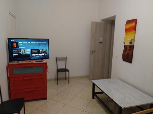 a living room with a television on a red dresser at Stella Marina - voglia di vacanza e di relax in Genova