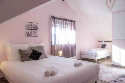 a bedroom with a large white bed with slippers on it at Nouveau - Le Funtastic - Europa Park Rulantica in Huttenheim