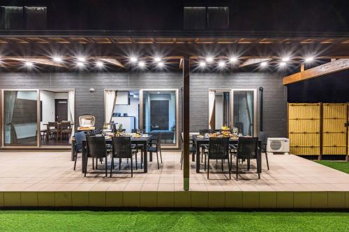 an outdoor dining area with tables and chairs at night at PEACE OF REST TAKASHIMA in Takashima