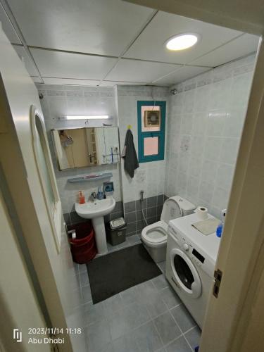 a small bathroom with a toilet and a sink at Bedroom 4 in Abu Dhabi